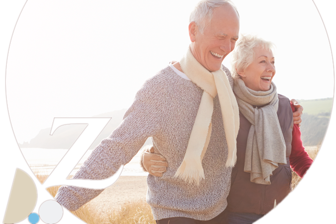 pareja senior paseando por la playa en invierno