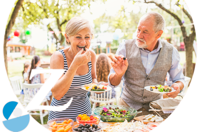 pareja mayor divertida comiendo al aire libre