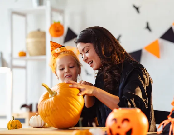 Madre e hija decorando una cabaza de Halloween en su casa