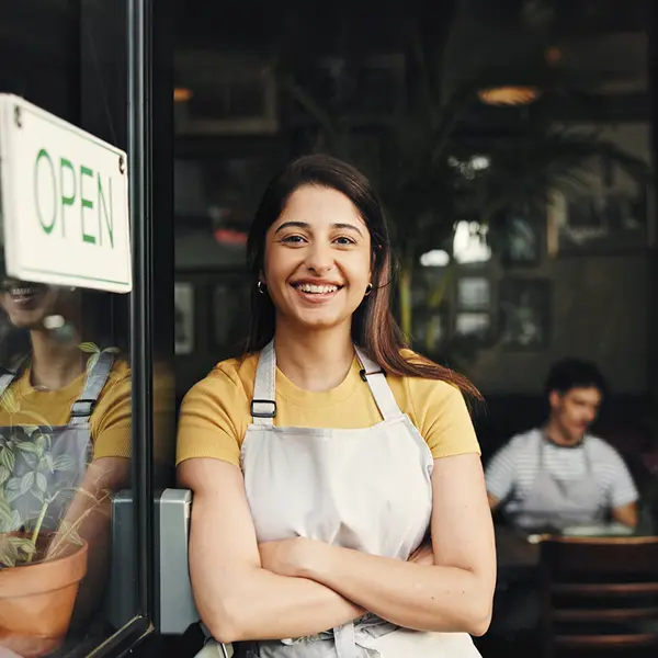 empleada de una cafetería sonriente mirando a cámara