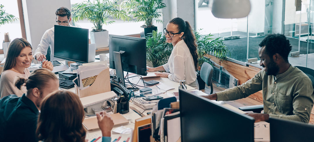 Diferentes trabajadores en una oficina con ordenadores en sus puestos